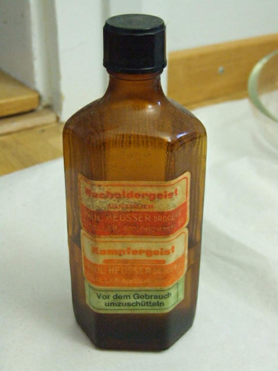 Braune Glasflasche mit Wacholdergeist resp,. Kampfergeist.