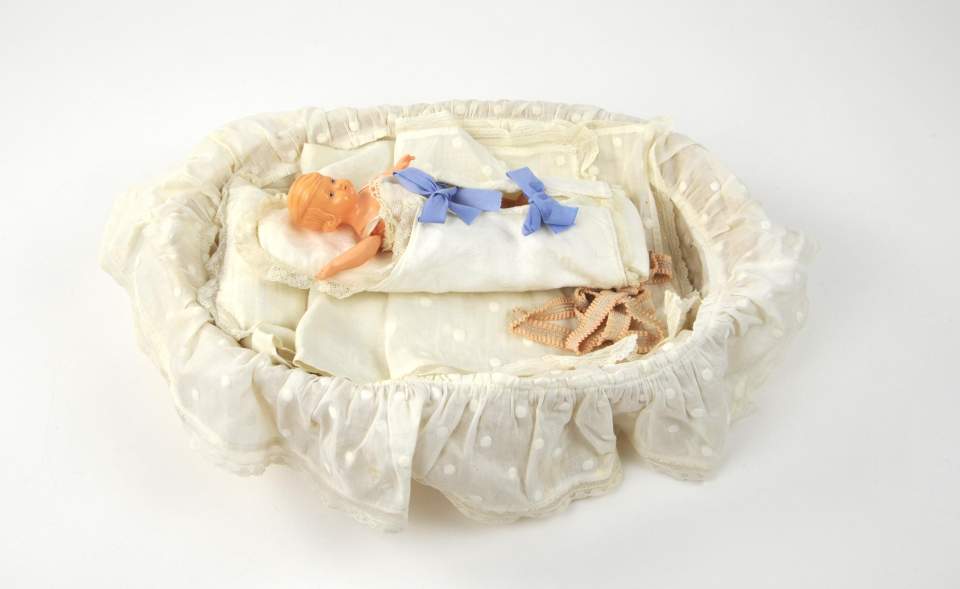 Puppenbett in Körbchen mit Puppe