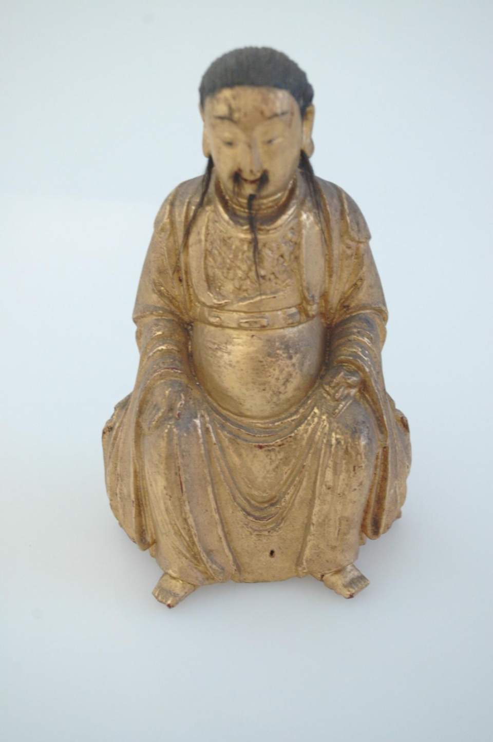 sitzende männliche Figur