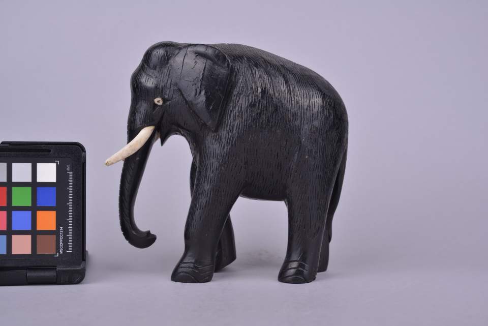 Elefant aus Holz mit zwei Stosszähnen