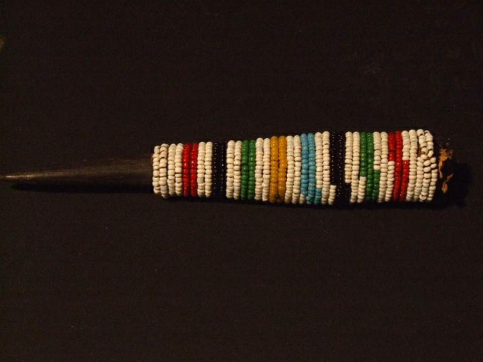 Horn mit Glasperlen umwickelt, zusammengeknülltes Papier darin