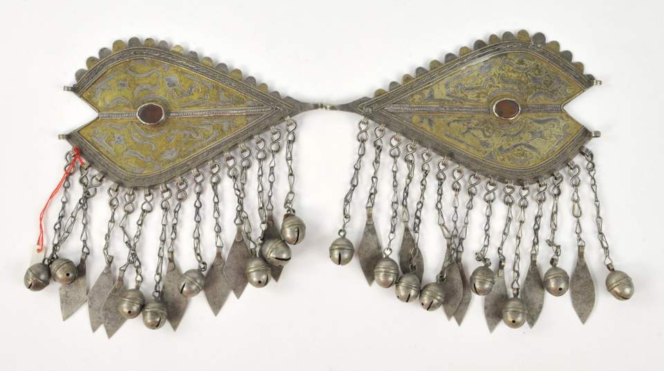 Paarweise getragener, in die Frauenhaube eingehakter Schmuck