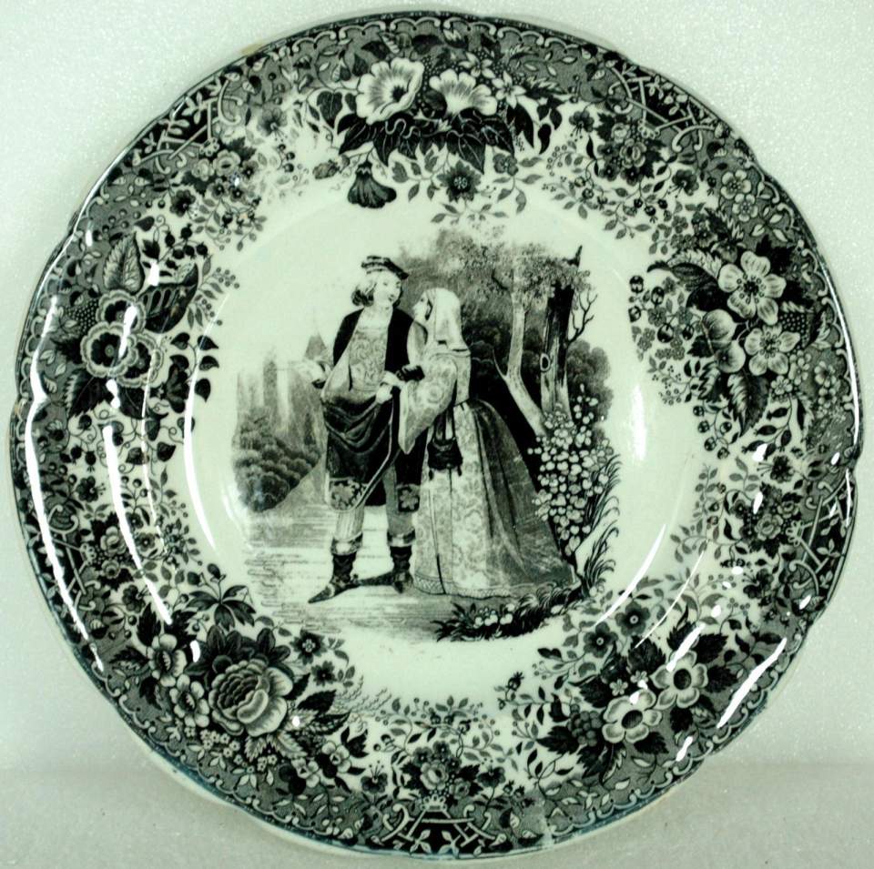 kleiner Teller,  silberne Denkmünze,  schwarzes Dekor mit Paar